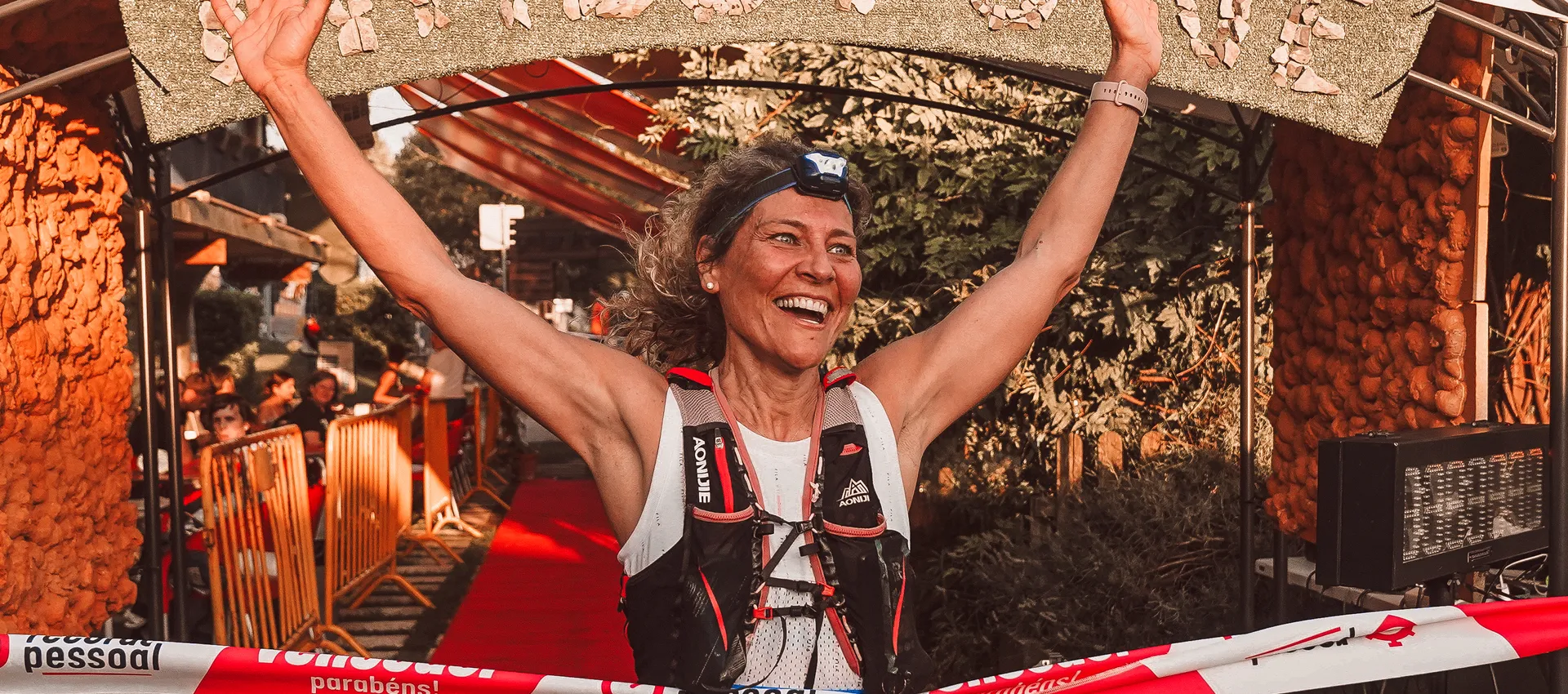A triumphant athlete crossing the finish line with arms raised