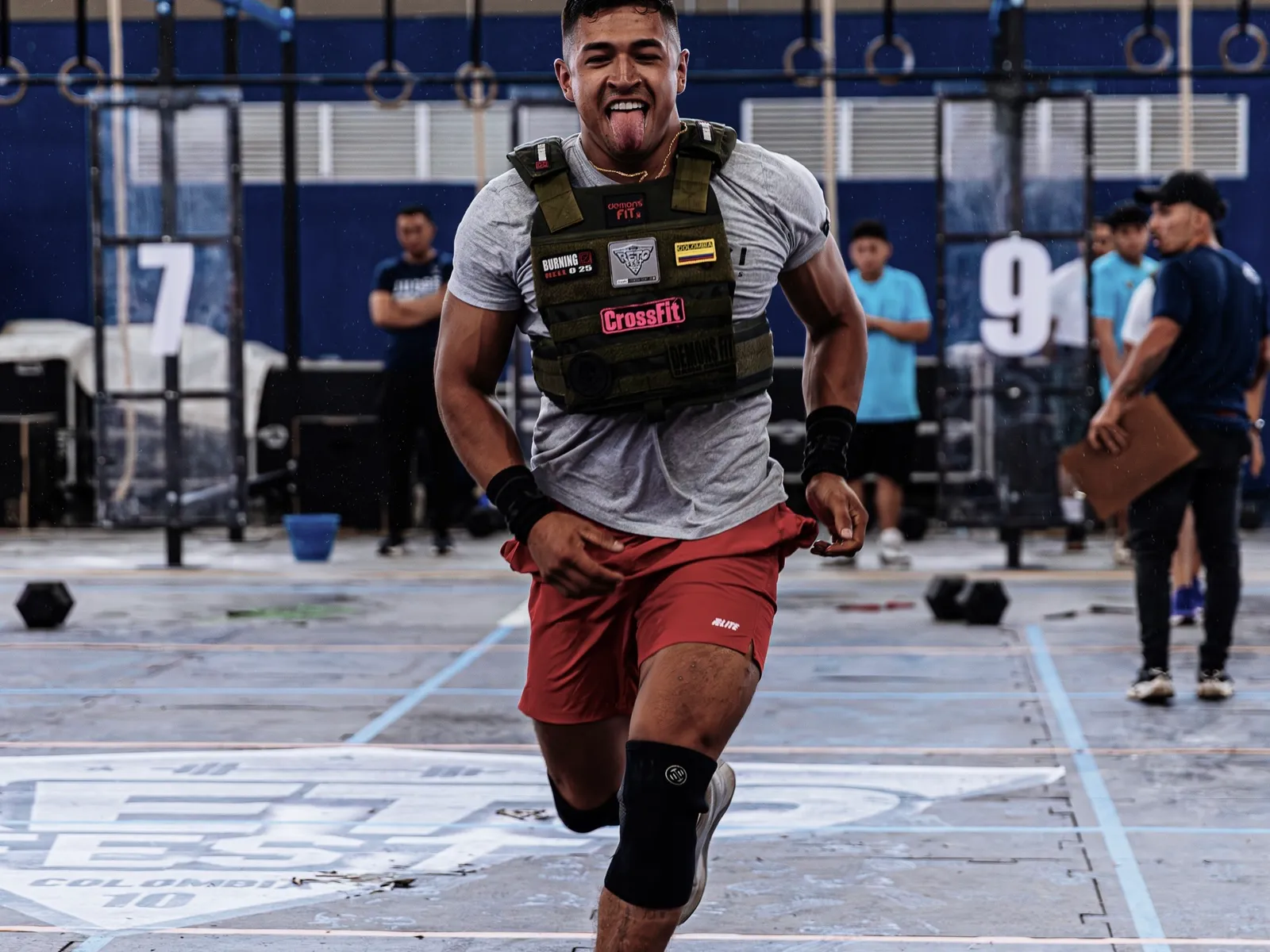 A determined athlete training hard in a knee brace at a fitness competition